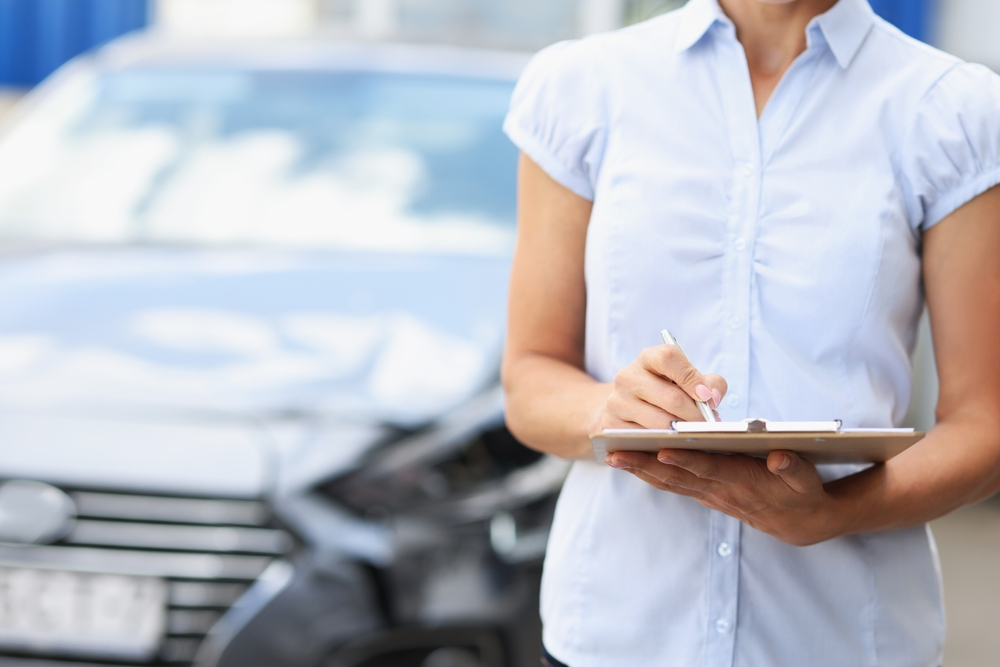 woman working in car glass replacement writing in a paper - Enhancing Vehicle Safety with Expert Door & Back Glass Replacement
