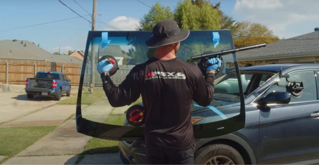 5 Signs You Need to Replace Your Windshield Immediately, apex auto glass professional holding a new windshield for replace