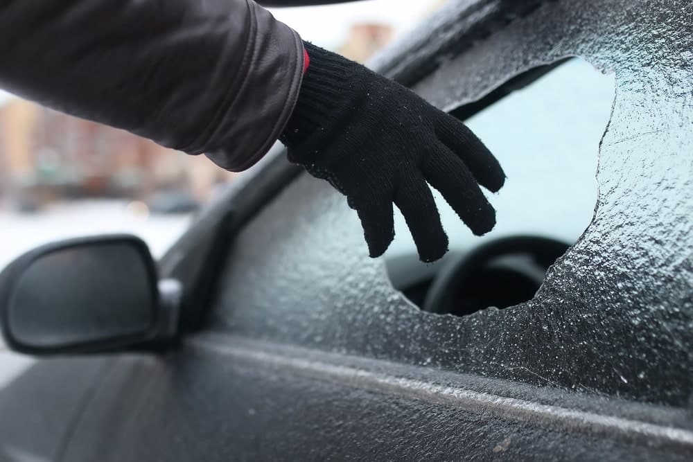A close-up photo of a car windshield covered in a layer of ice. Highlighting the potential dangers of ignoring windshield chips during cold weather.