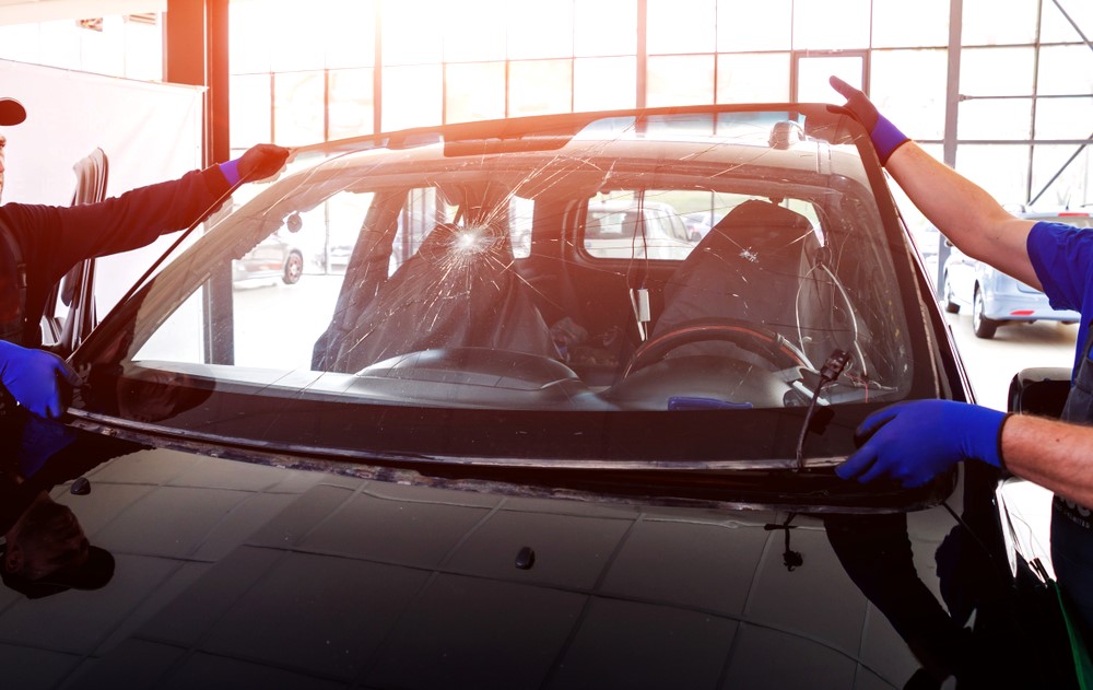 Automobile special workers remove old windshield of a car - auto glass repair new orleans