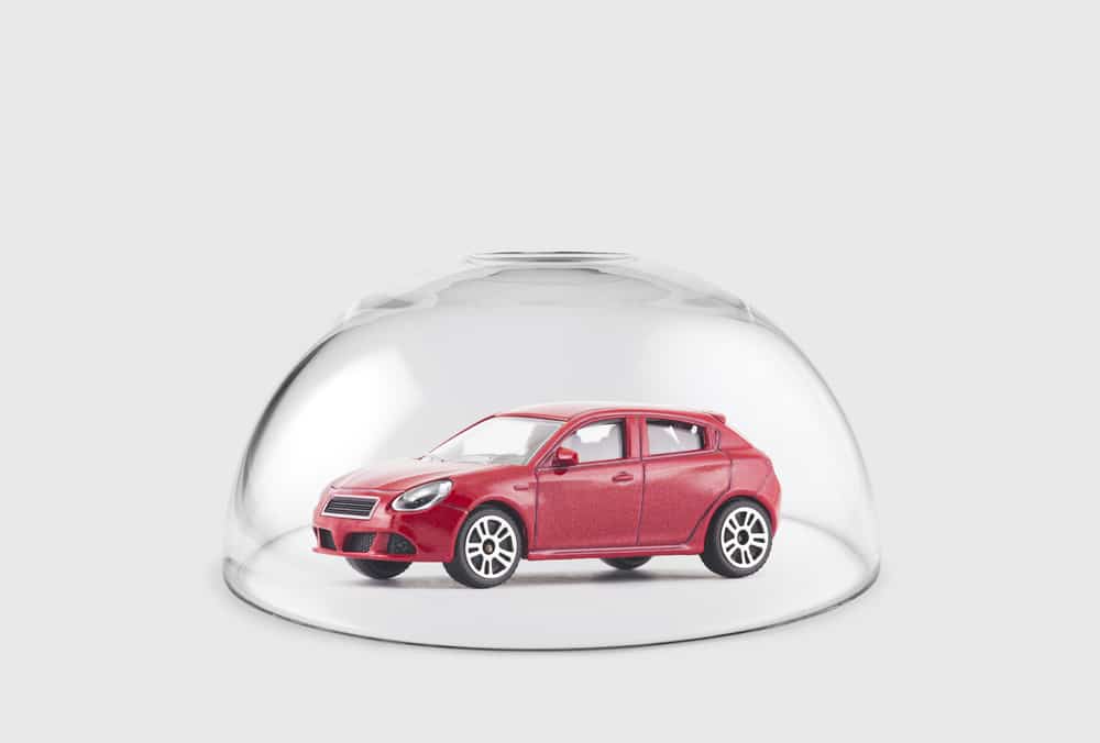 Red car protected under a glass dome - auto glass repair new orleans - apex auto glass